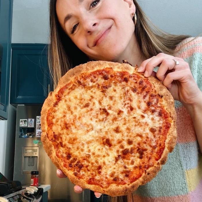 Lindsay holding a pizza.