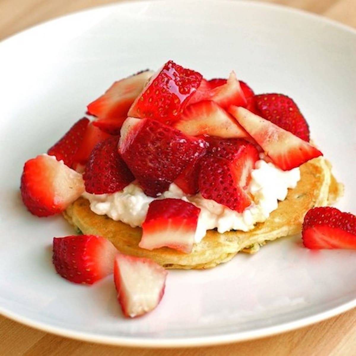Zucchini pancakes with strawberries and whipped cream.