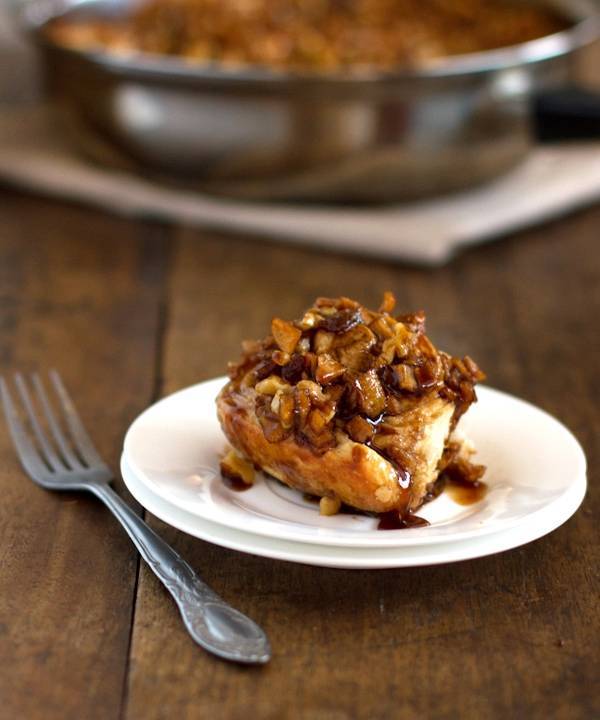 Caramel roll on a white plate with a fork.