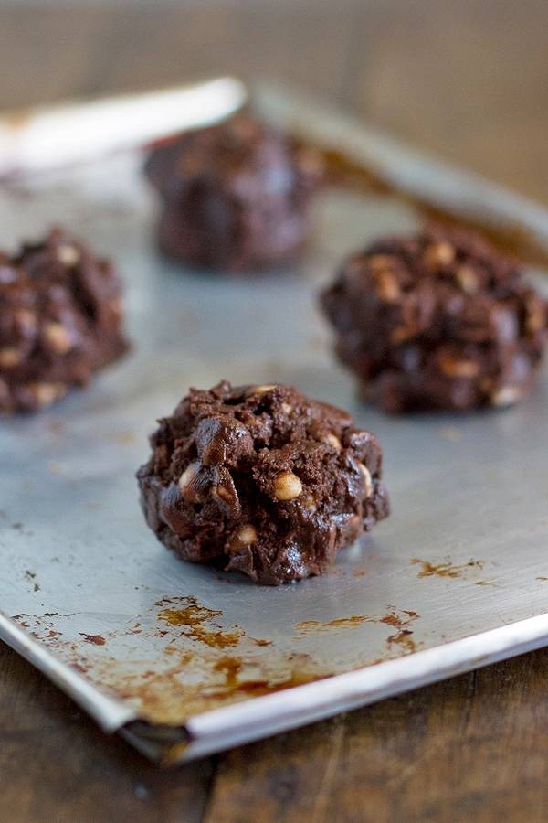 Not yet baked double chocolate cake mix cookies on a baking pan.
