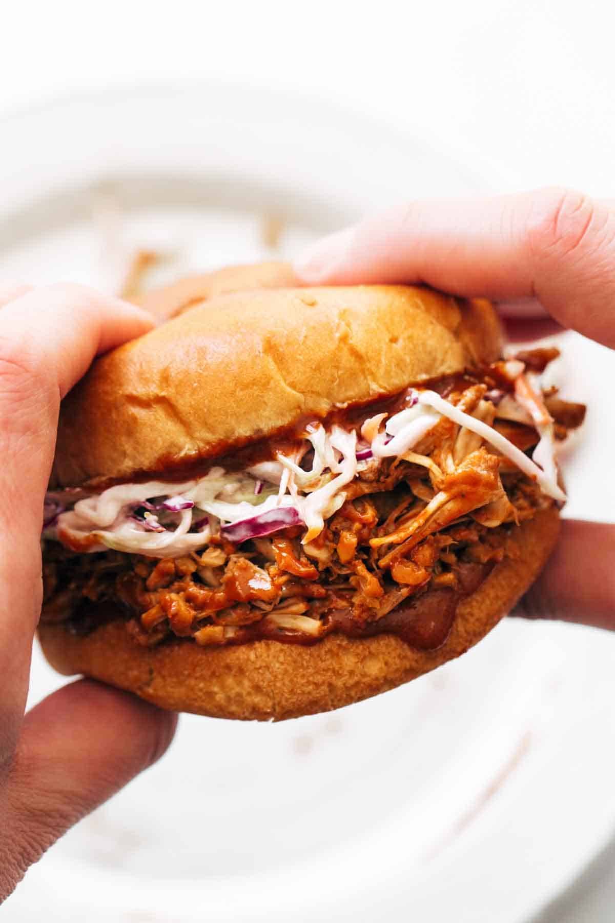 Person holding a BBQ Jackfruit Sandwich.
