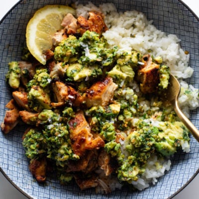 Chipotle chicken in a bowl with rice and chunky pistachio sauce.