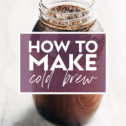 Image of a mason jar filled with coffee grounds and water steeping to make cold brew. There's text over the jar that says "How to Make Cold Brew"