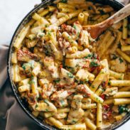 Sun Dried Tomato Chicken Florentine Pasta in a pan with a spoon.