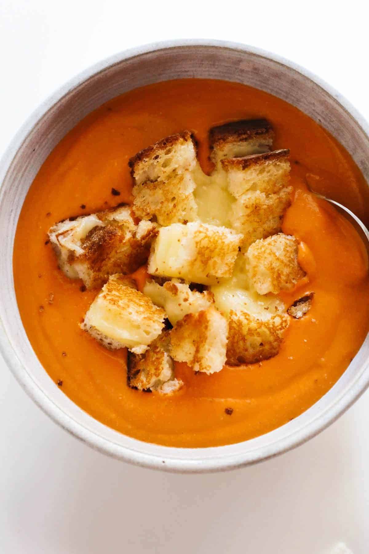 A bowl of tomato soup with the grilled cheese .